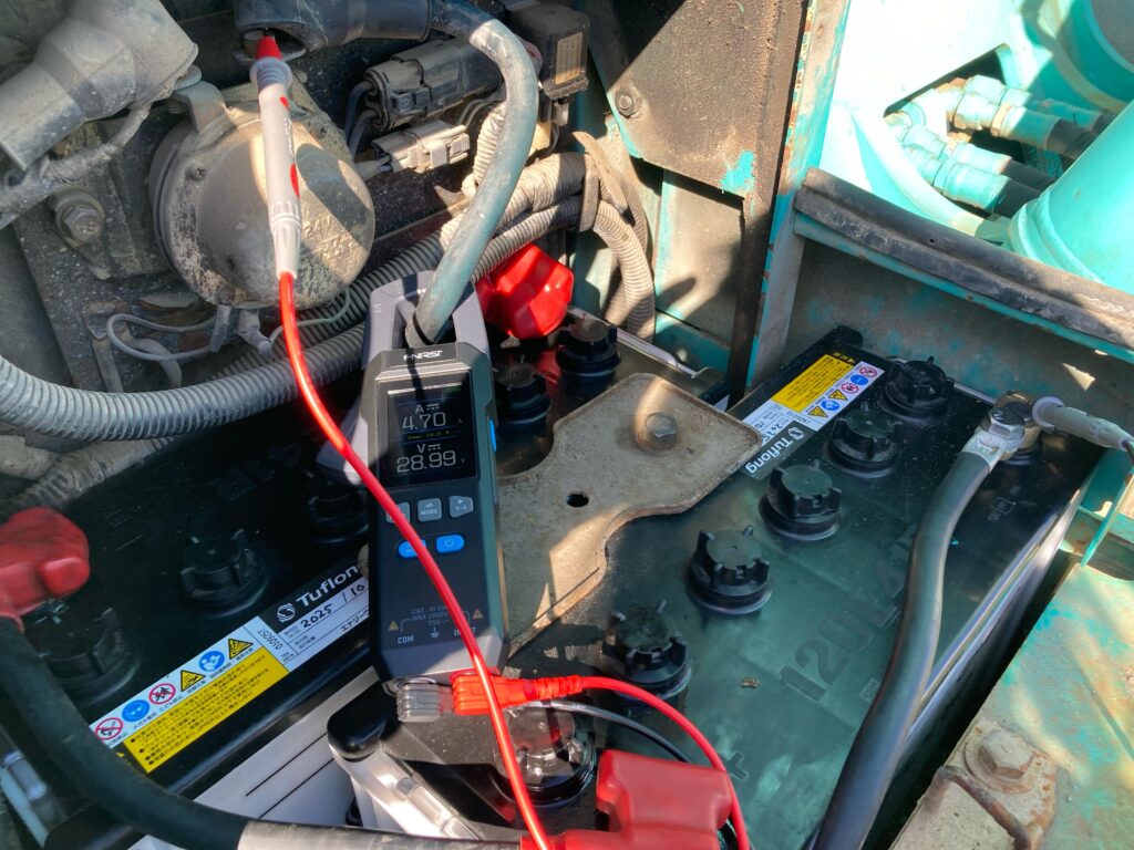 クランプメーターを使用してSK135SRのバッテリー充電状態を確認している作業風景02